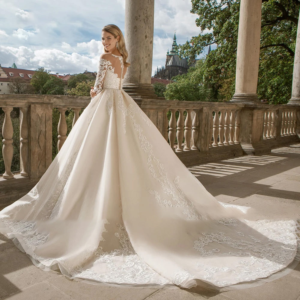 Detailed back profile of an A-line wedding dress with a sheer illusion lace back and a sweeping court train.