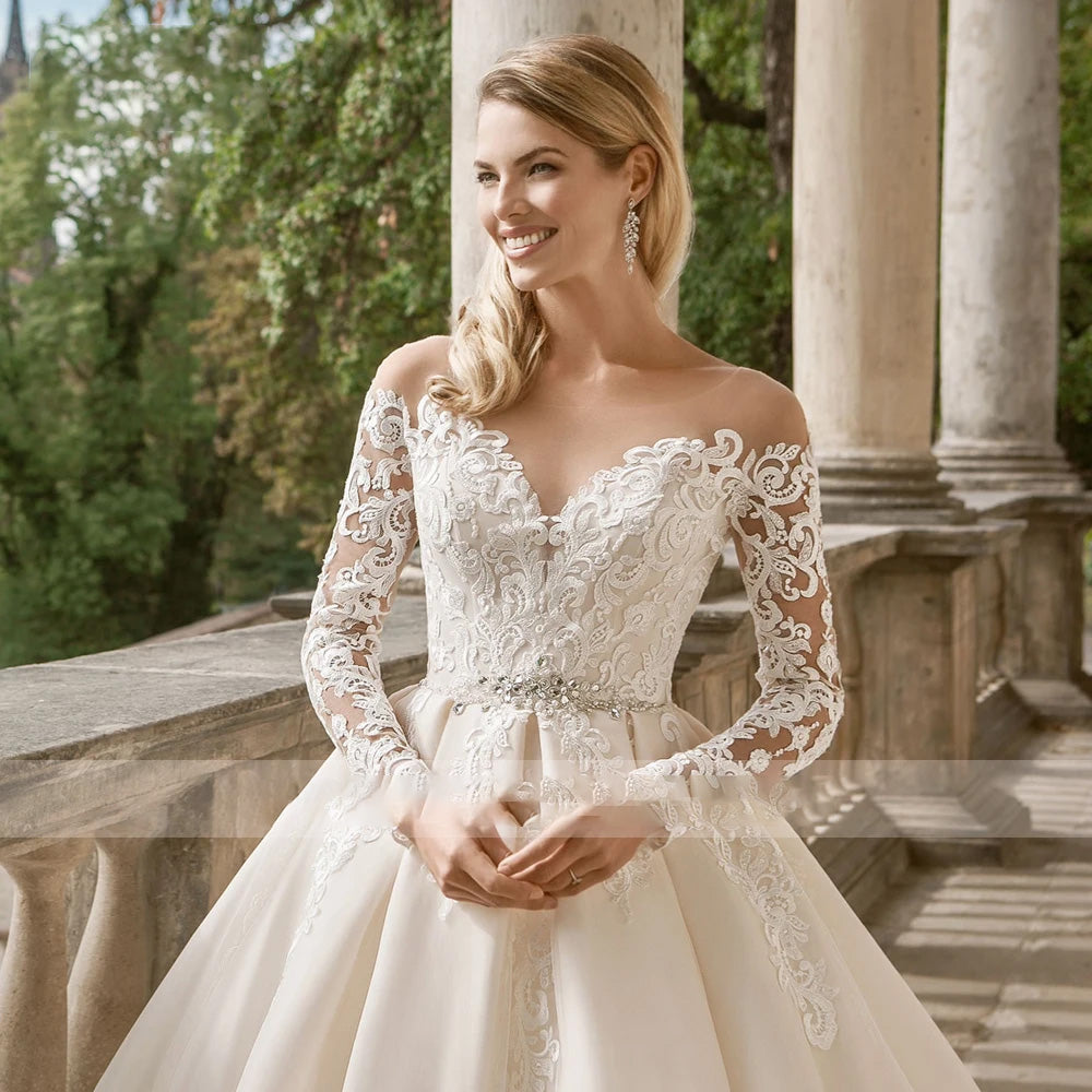Close-up of the elegant bodice and long lace sleeves of a luxury vintage-inspired A-line bridal gown.