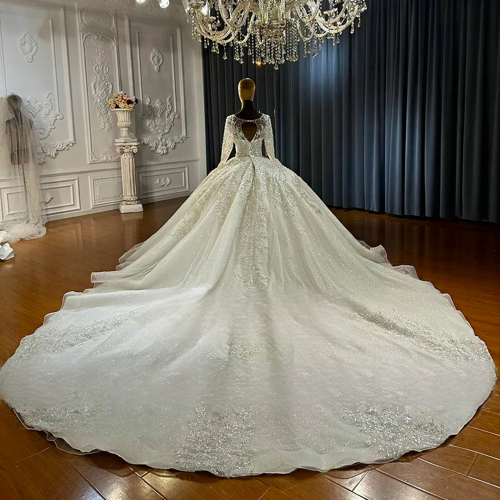 Rear view of a luxury bridal gown on a mannequin, highlighting the elegant lace-up corset back and a majestic, sweeping cathedral-length train with delicate embroidery.