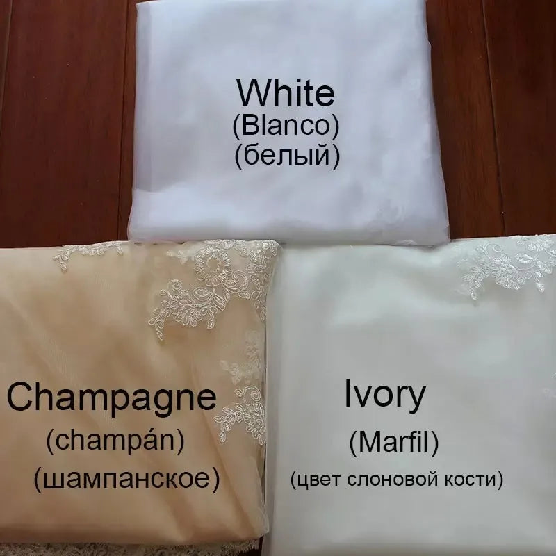 Textured textile swatches showcasing the White, Champagne, and Ivory material color options with delicate lace applique accents for custom bridal gown orders.
