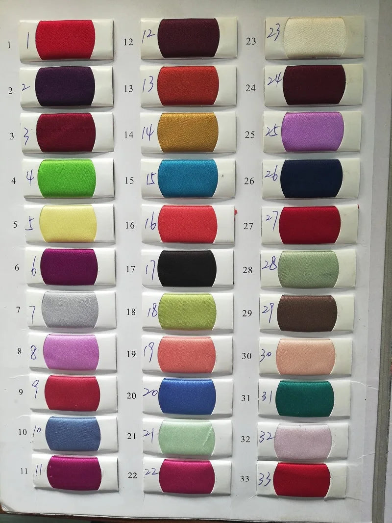Numbered fabric color catalog displaying custom color variations and glossy satin textile swatches for tailored cocktail dresses and reception gowns.