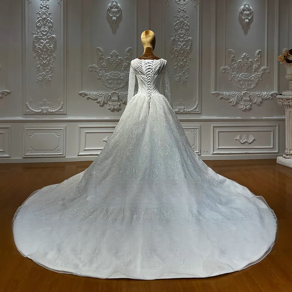 Detailed rear view of a sparkling A-line bridal dress with a cathedral-length train, showcasing the intricate glitter embroidery and structured lace-up back.