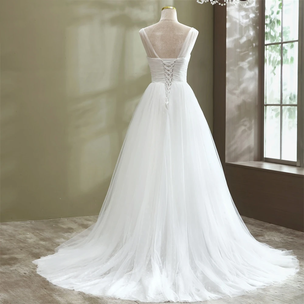 Rear view of an elegant A-line tulle wedding dress featuring a lace-up corset back detail and a romantic floor-length train.