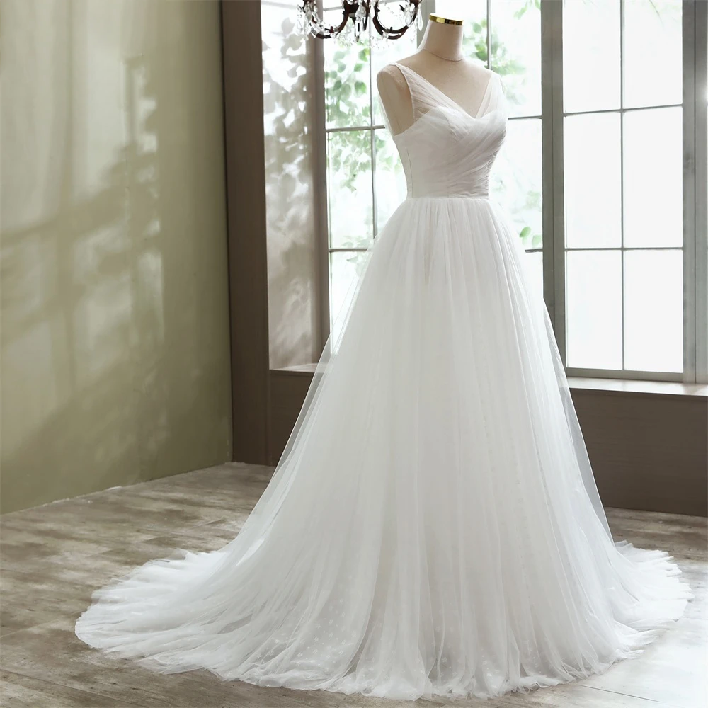 Elegant A-line tulle bridal gown with a delicate V-neckline, designed for a sophisticated and comfortable beach wedding look.
