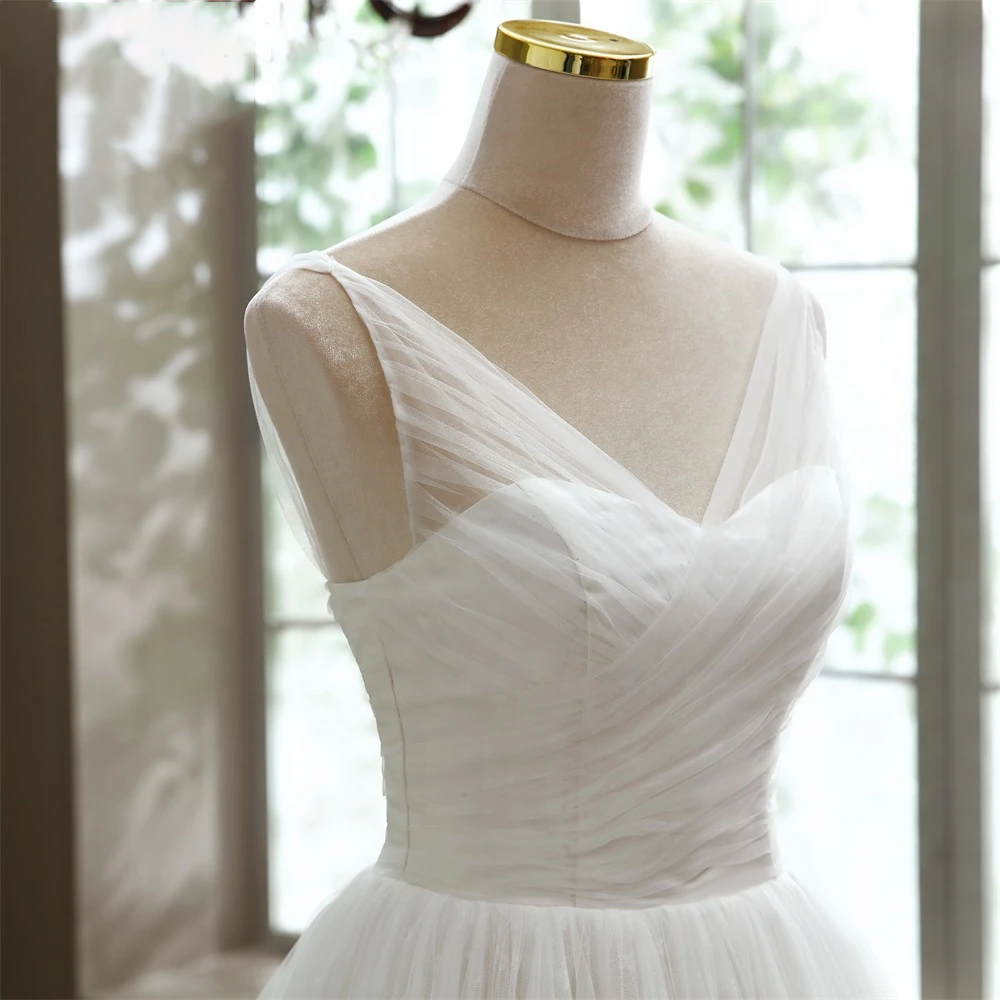 Close-up detail of the elegant V-neck bodice and tulle overlay on an A-line bridal gown.