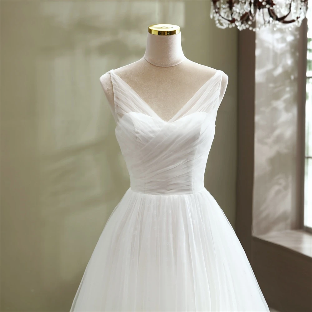 Studio view focusing on the sweetheart neckline and draped bodice of an elegant A-line tulle wedding dress.