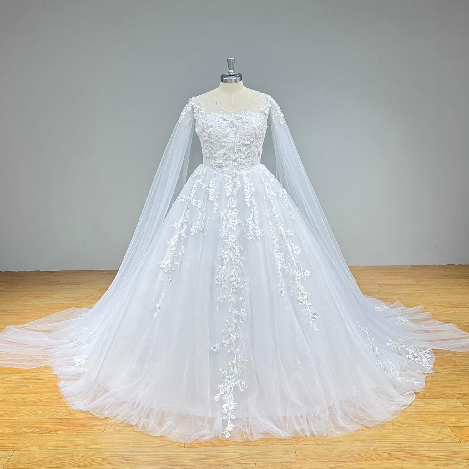 Classic full front view of an elegant ball gown wedding dress on a mannequin, highlighting the voluminous tulle skirt adorned with cascading vintage lace and dramatic long sheer shawl sleeves.