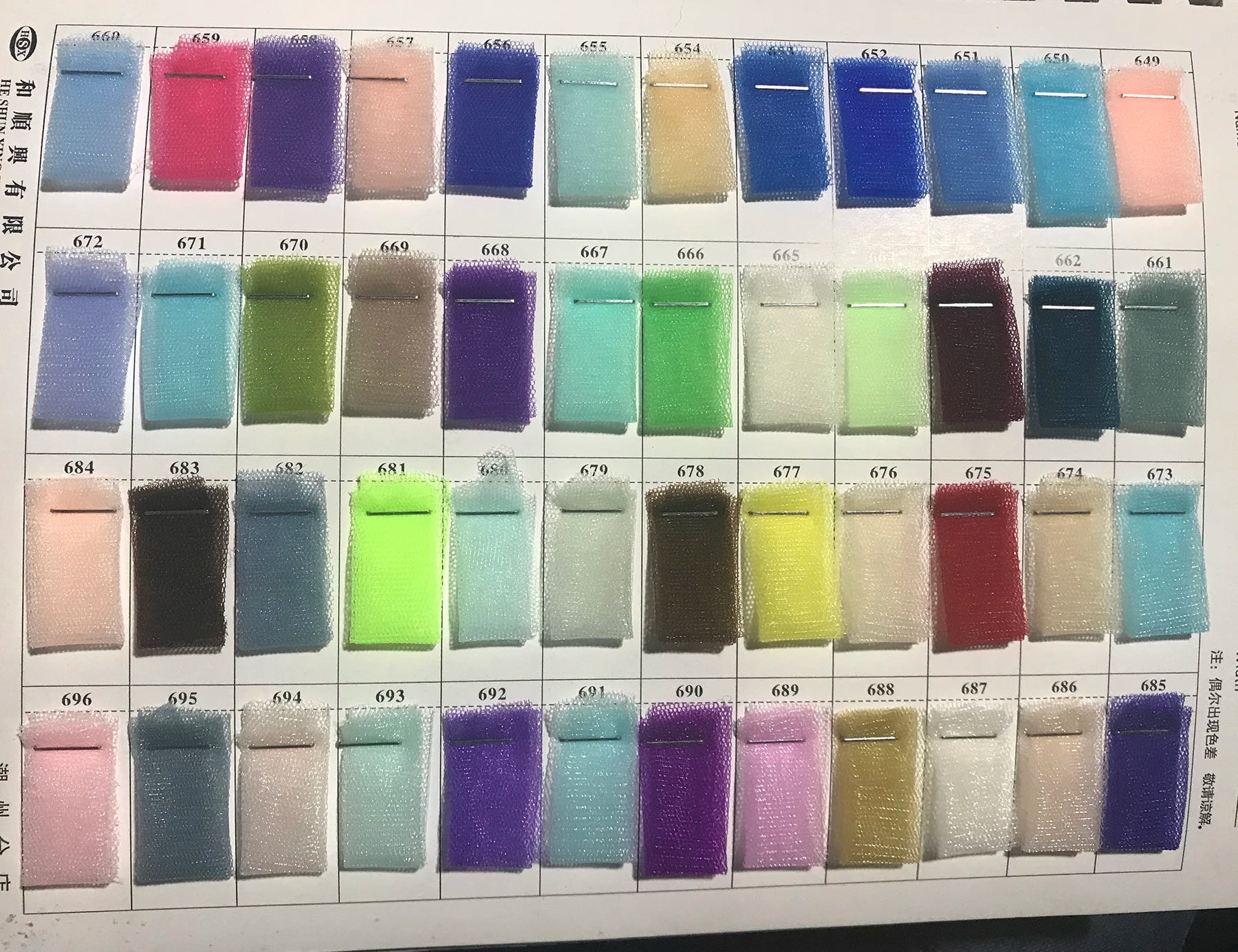 Comprehensive fabric color swatch chart displaying numbered rows of sheer tulle and mesh textile samples for custom wedding dress color selections.