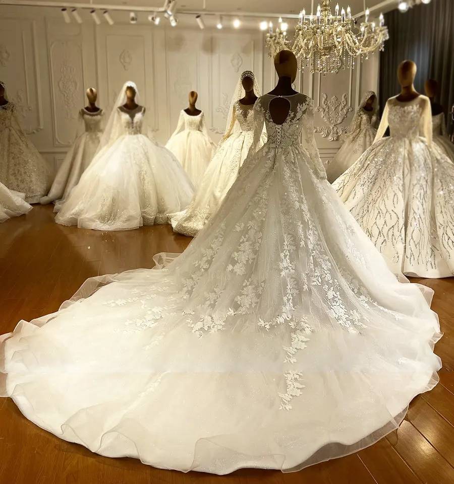 Stunning cathedral-length lace train of an elegant romantic bridal gown laid out in a luxury wedding showroom.