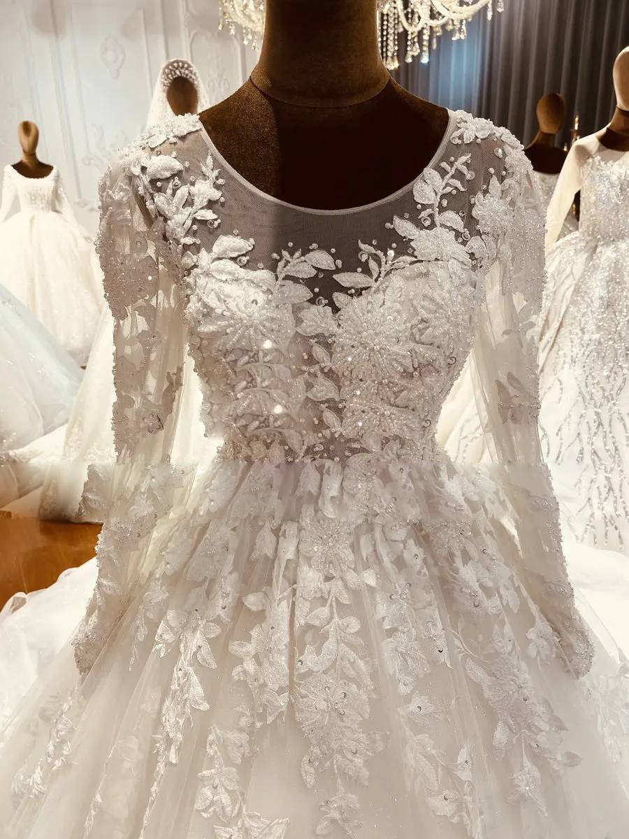 High-resolution close-up of the intricate floral lace embroidery and sequin beadwork on the bodice of an elegant bridal gown.
