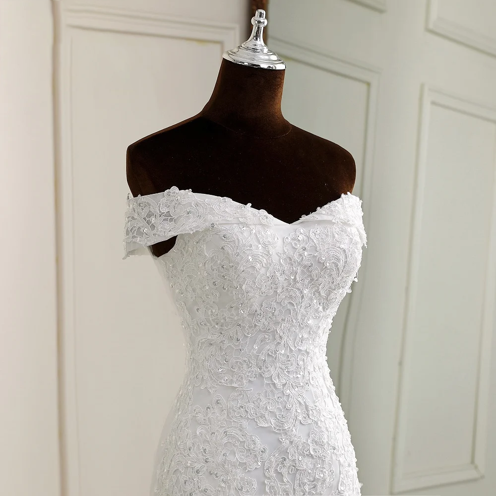 Rear view of an off-shoulder boat neck mermaid wedding dress showing the corset lace-up detail and a flowing train.