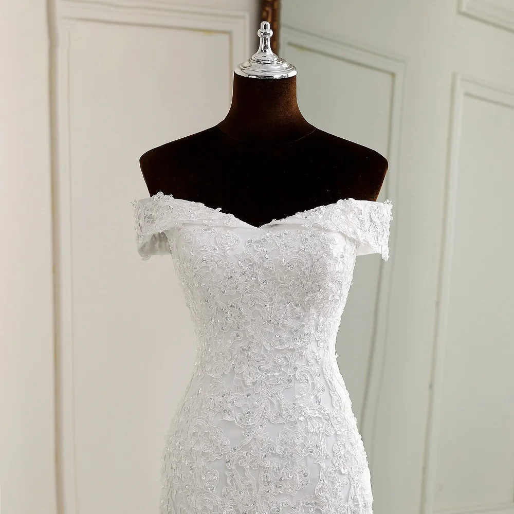 Close-up of the bodice on an off-shoulder boat neck mermaid wedding dress, highlighting intricate beadwork and lace appliques.