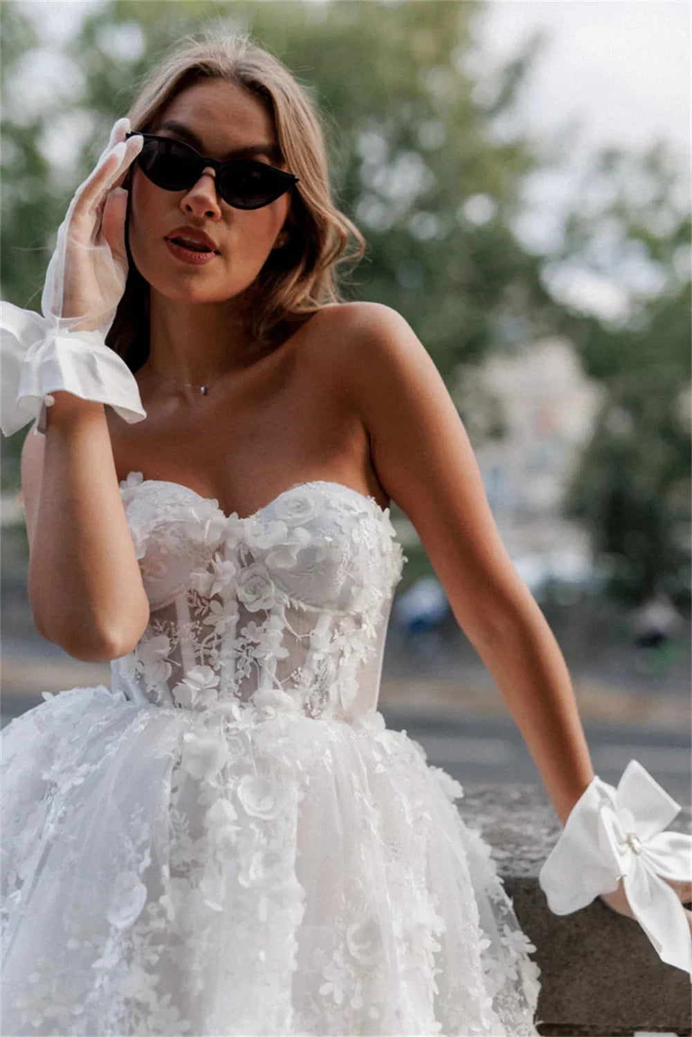 Close-up of an elegant white mini prom dress, highlighting the heart-shaped sweetheart bodice and detailed floral lace appliques.