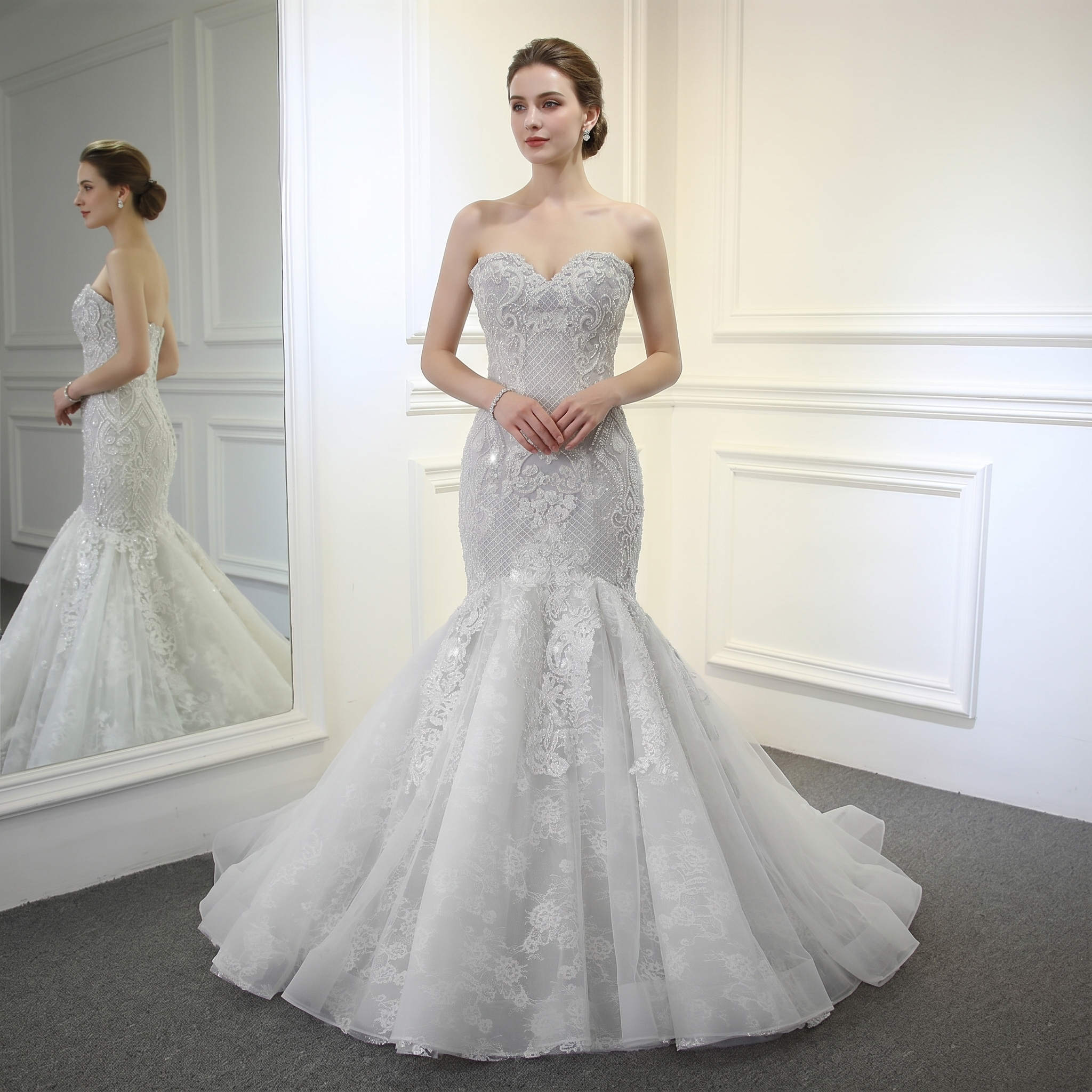 Full-length front view of an elegant champagne mermaid bridal gown featuring full beaded detailing and a sweetheart neckline on a model.