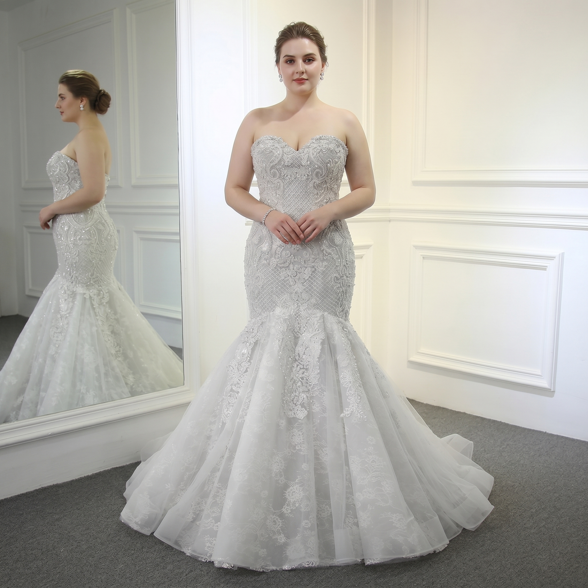 Plus-size model wearing a stunning champagne beaded mermaid wedding dress with a flared lace and tulle skirt.