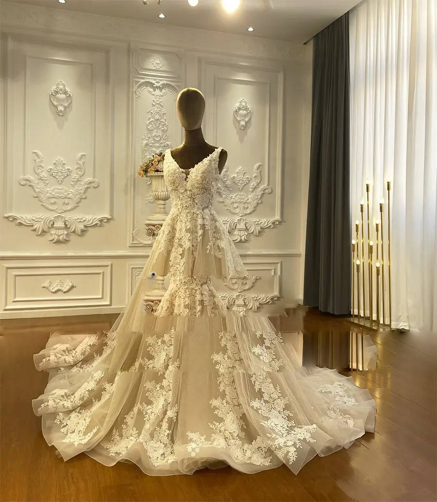 Front view of the champagne bridal gown on a mannequin, showcasing the flowy tulle skirt and lace appliques.