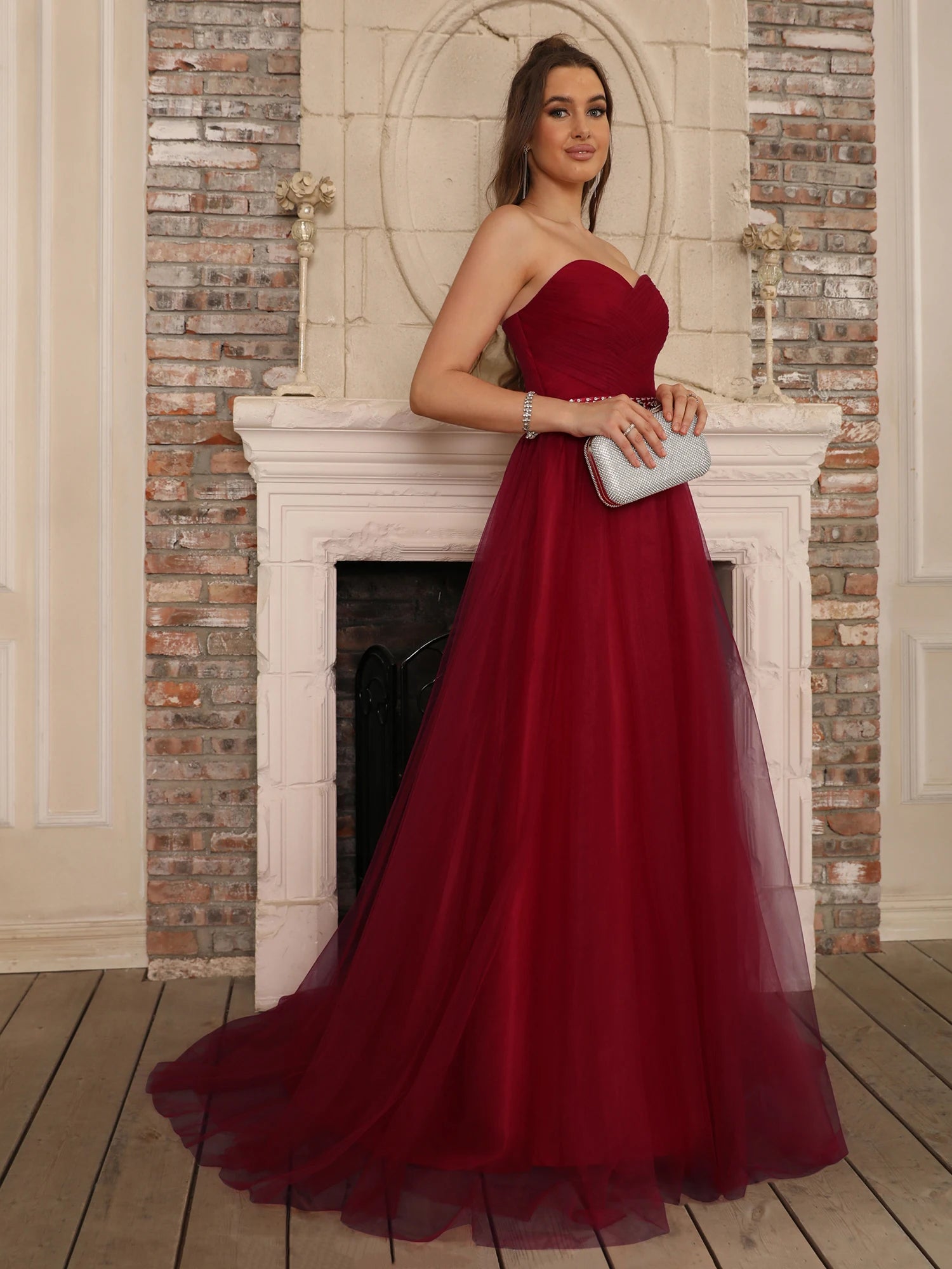 A-line burgundy evening gown with a sweetheart bodice and crystal-embellished waistline, showcasing the flowing chiffon skirt.