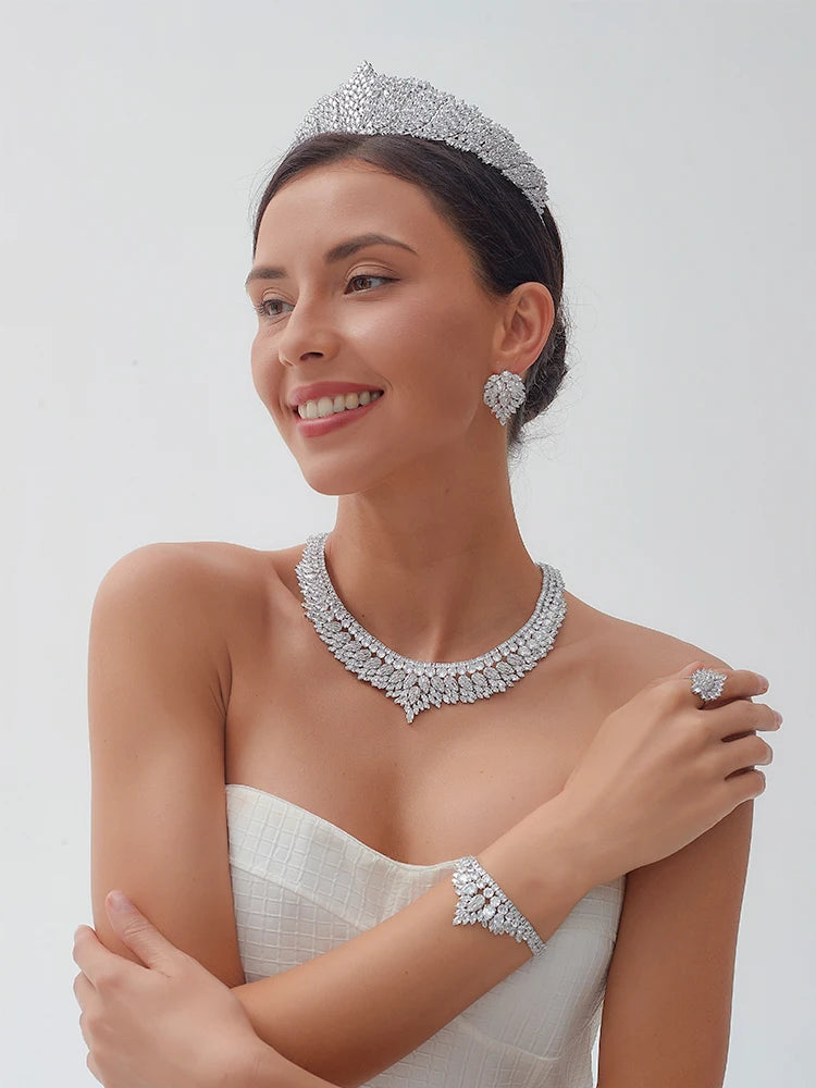 Smiling model wearing an elegant cubic zirconia bridal crown headband with matching crystal wedding necklace, earrings, and bracelet