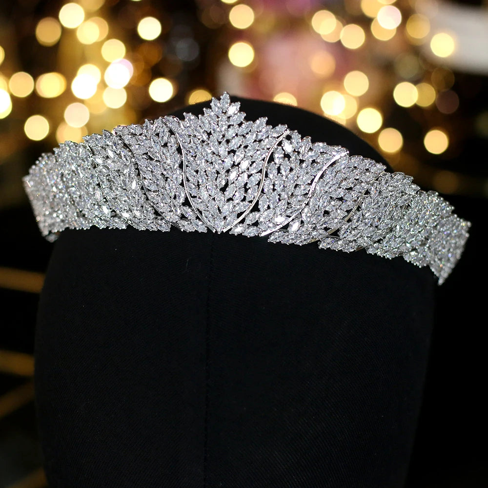 Front profile of a luxury cubic zirconia bridal tiara crown with a layered marquise-cut leaf pattern on a black mannequin display.