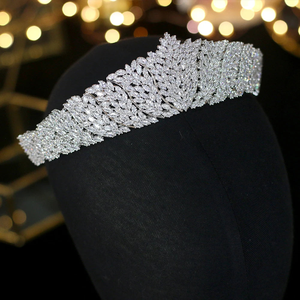 Side-profile view of a sparkling rhinestone bridal crown headband for women, balanced elegantly on a black display stand.