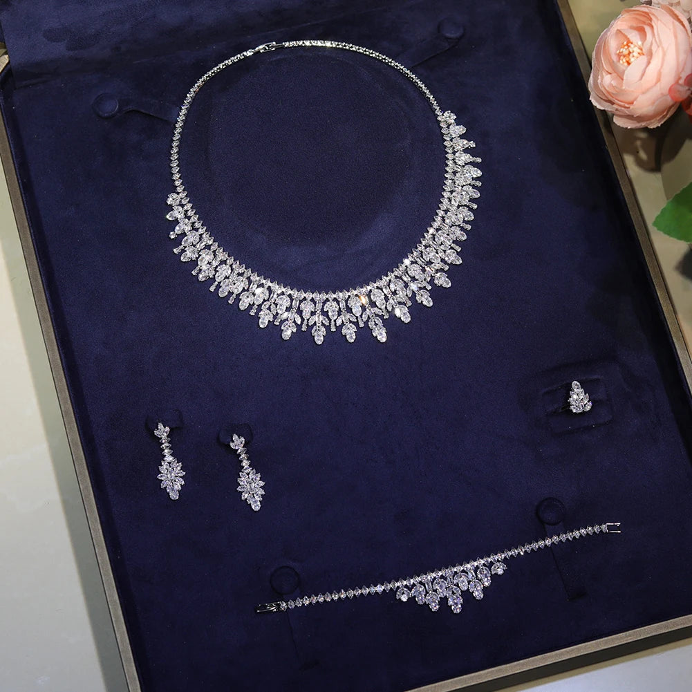 Premium 4 pieces cubic zirconia bridal flower necklace, bracelet, earrings, and ring set beautifully arranged in a dark blue velvet gift box.