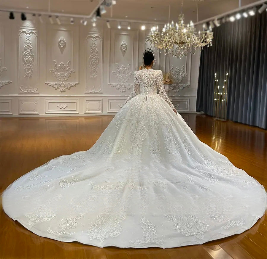 Breathtaking rear view of the elegant full lace ball gown wedding dress, emphasizing the regal cathedral-length train adorned with intricate shimmering lace detailing.