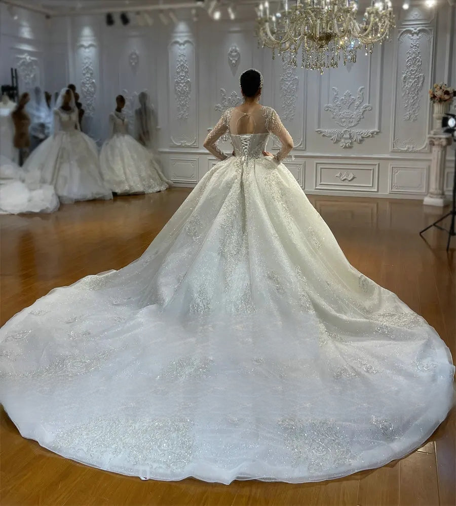 Breathtaking rear view of a luxury vintage ball gown on a mannequin, showcasing the traditional lace-up corset back and an expansive shimmering cathedral-length train.