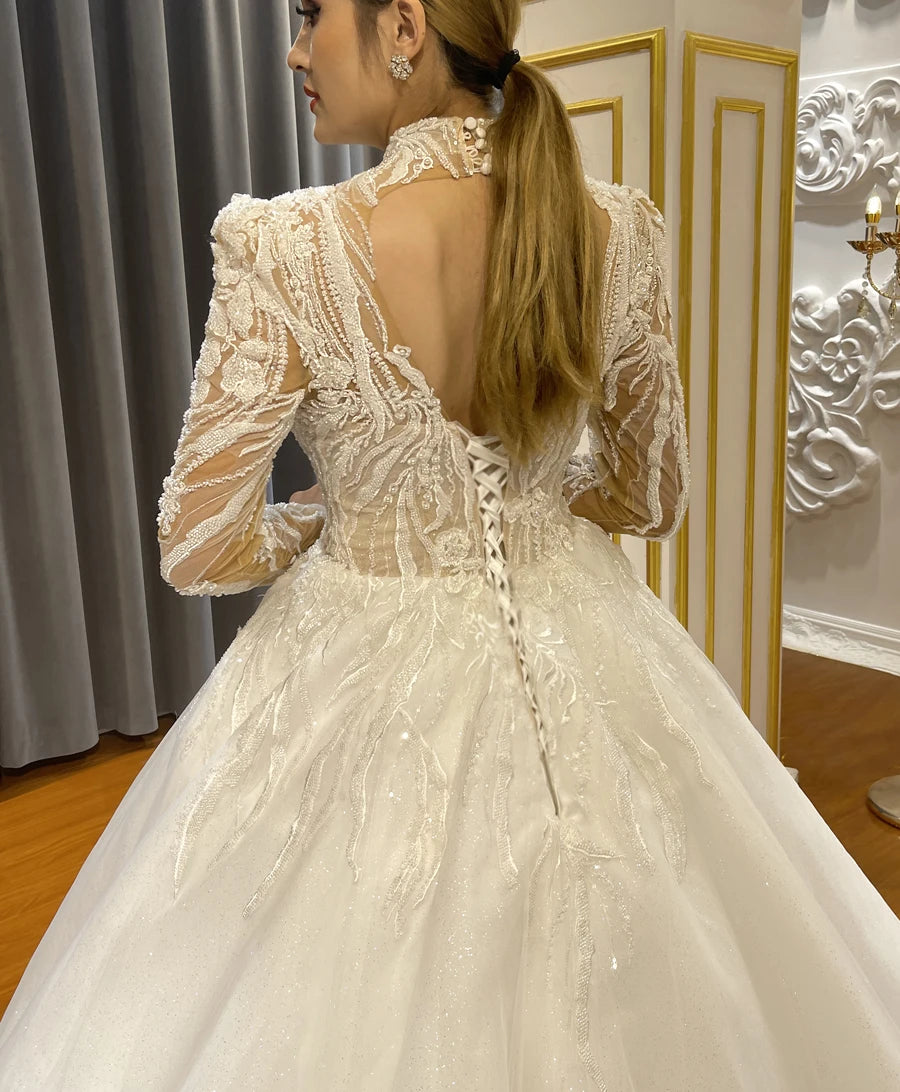 Back detail of a beaded illusion wedding dress featuring a sophisticated keyhole back, floral lace embroidery, and a classic white corset lace-up closure.