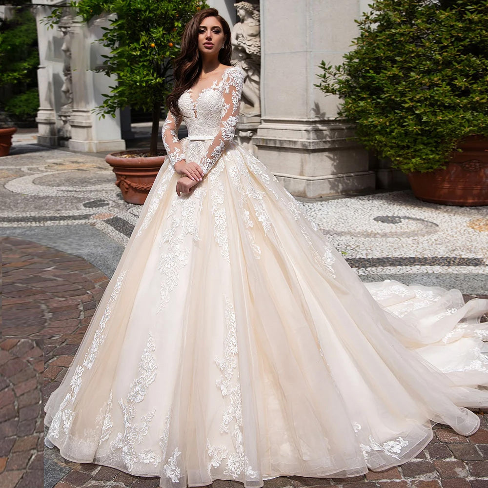 Elegant illusion A-line wedding dress with long lace sleeves and scoop neckline.