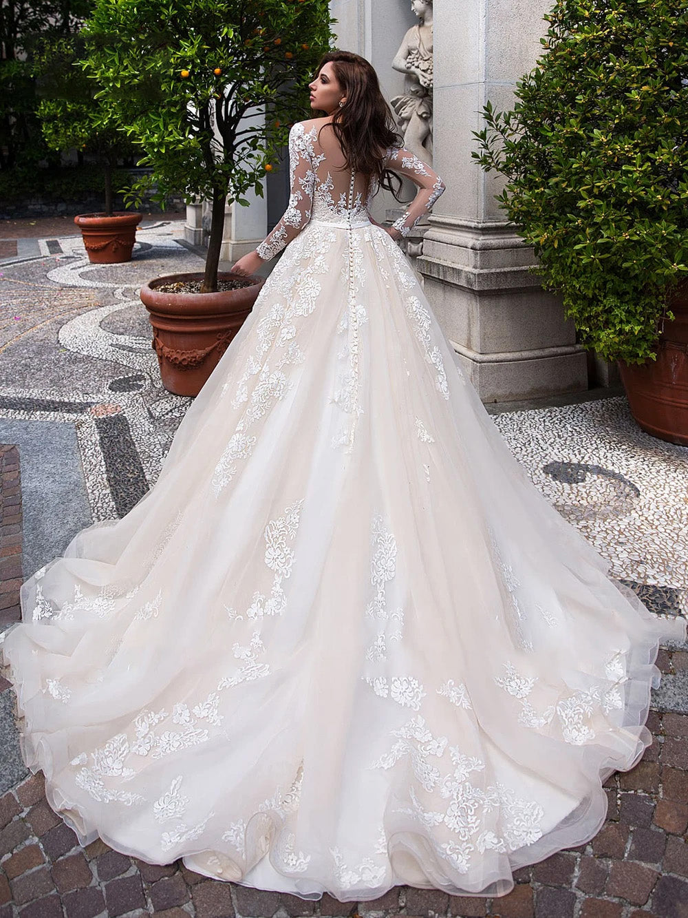 Back view of luxury A-line bridal gown featuring lace appliques and button-up detail.