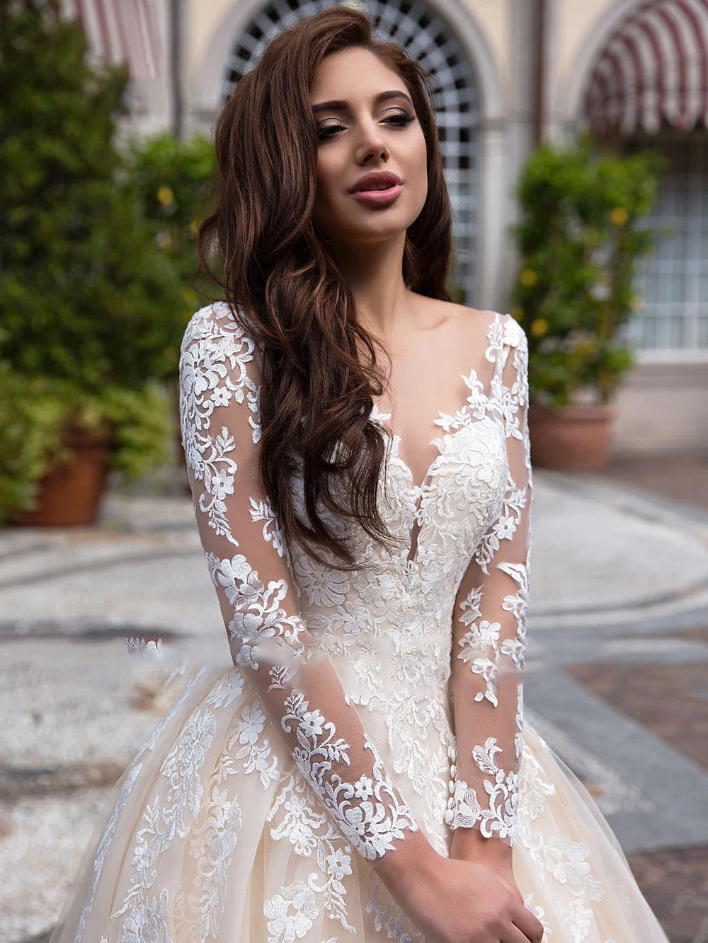 Close-up of scoop neck bodice on vintage-style A-line wedding dress with intricate lace sleeves.