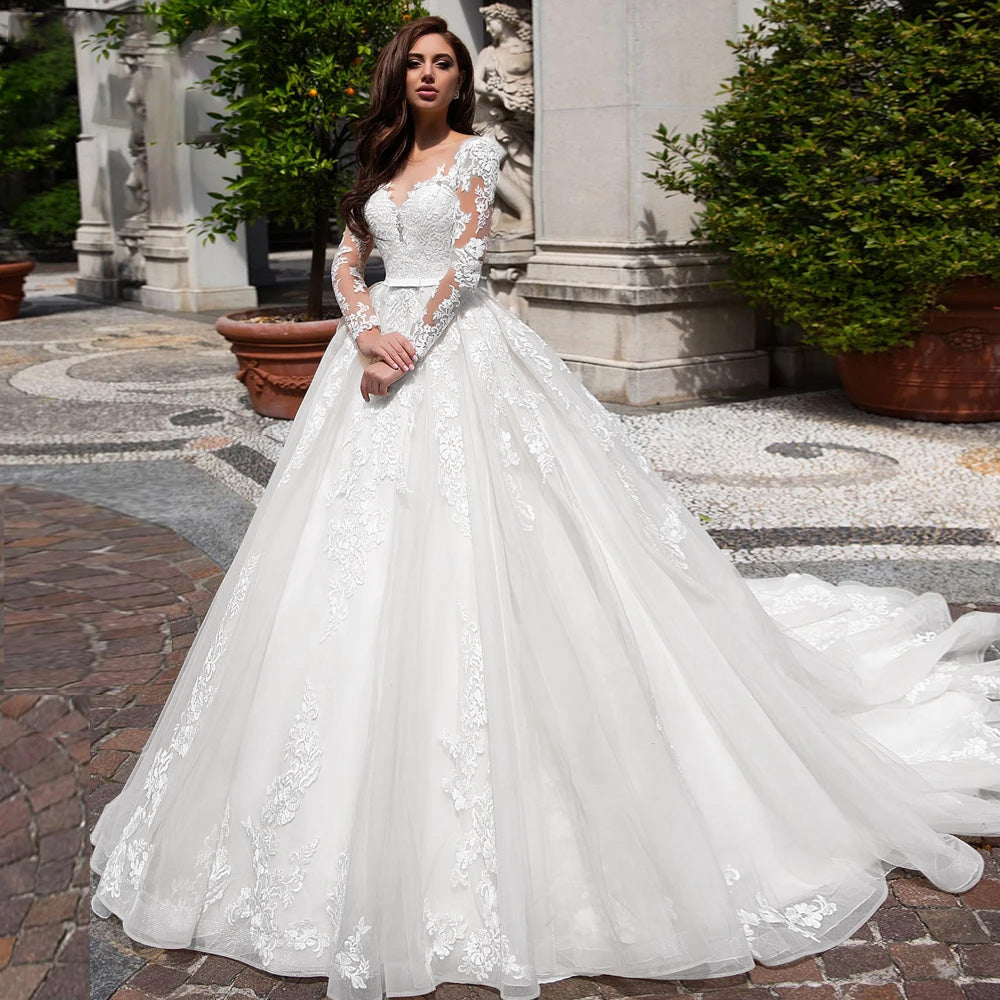 Full-length view of white A-line wedding dress with court train and floral lace appliques.