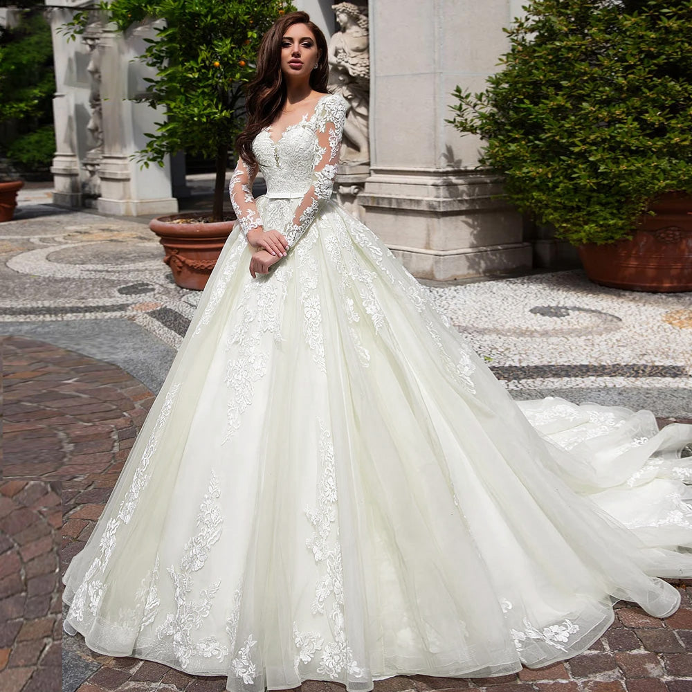 Luxury scoop neck A-line bridal gown with long lace sleeves, captured in outdoor garden setting.