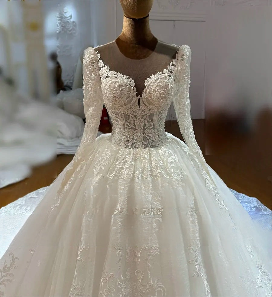 Close-up detail of a romantic bridal gown bodice featuring intricate floral lace appliqués and a plunging illusion V-neckline.