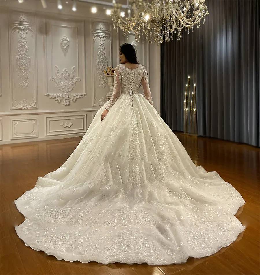 Back view of a timeless bridal gown featuring a dramatic cathedral-length lace train and elegant button details.