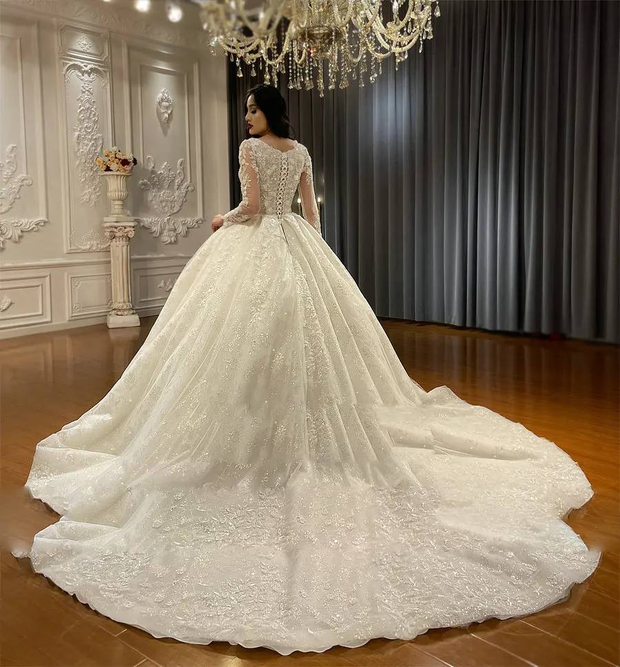 Ornate lace wedding dress with a long, sparkling train and a structured bodice for a classic, high-glamour bridal look.
