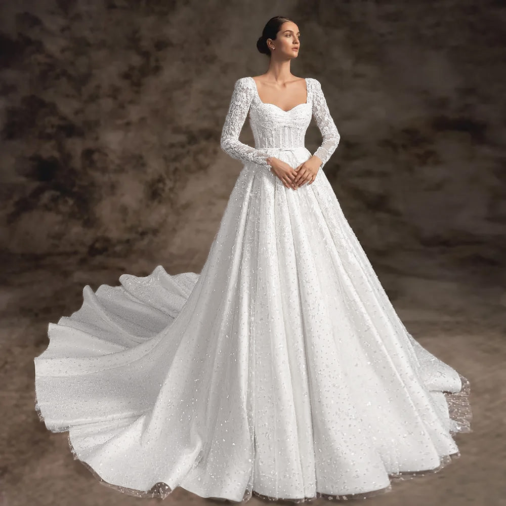 Sophisticated long-sleeve A-line princess bridal gown with sparkling details and a flowing court train.