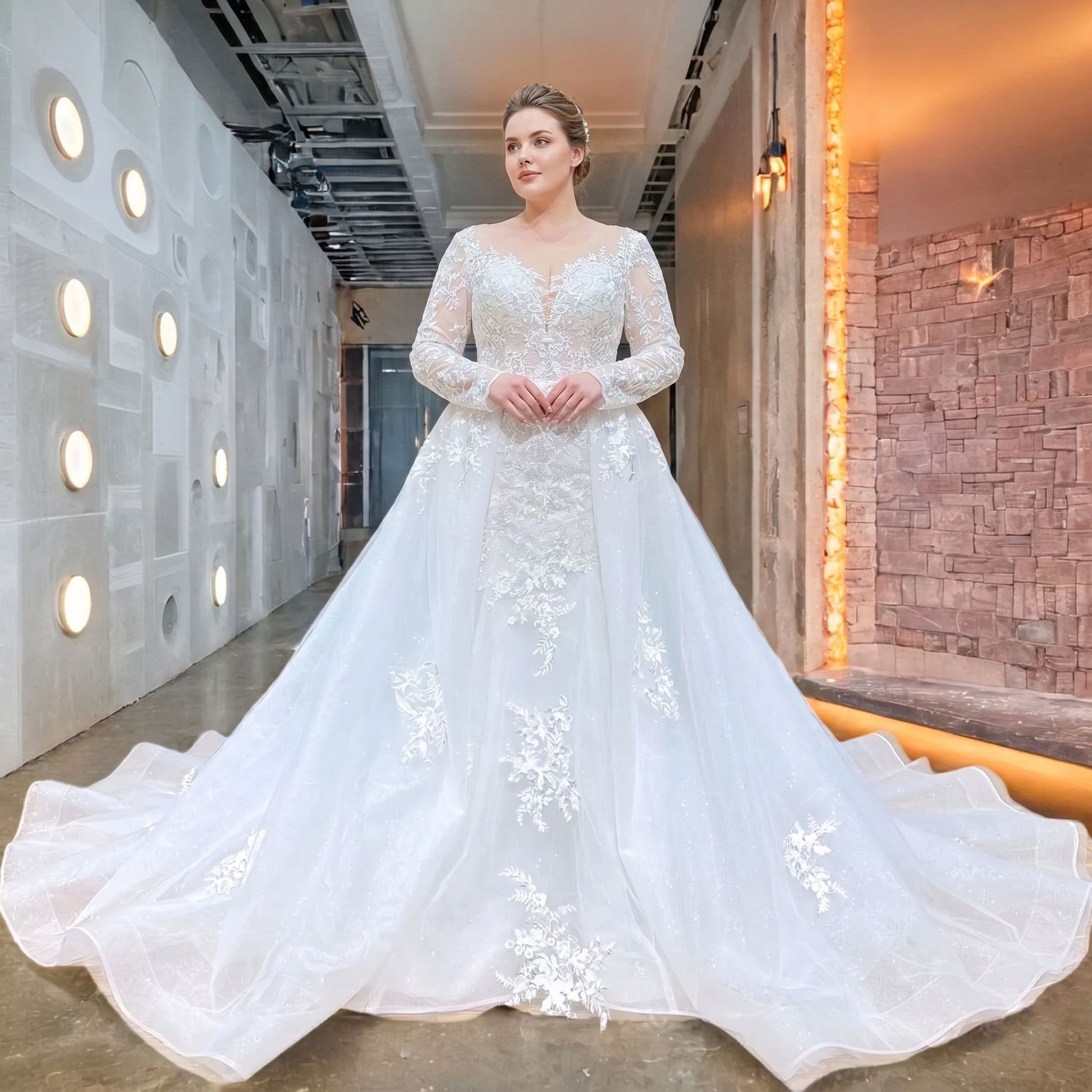 Full-length front view of a plus-size bride wearing an elegant long sleeve mermaid wedding dress, highlighted by detailed lace appliques and a majestic detachable train.