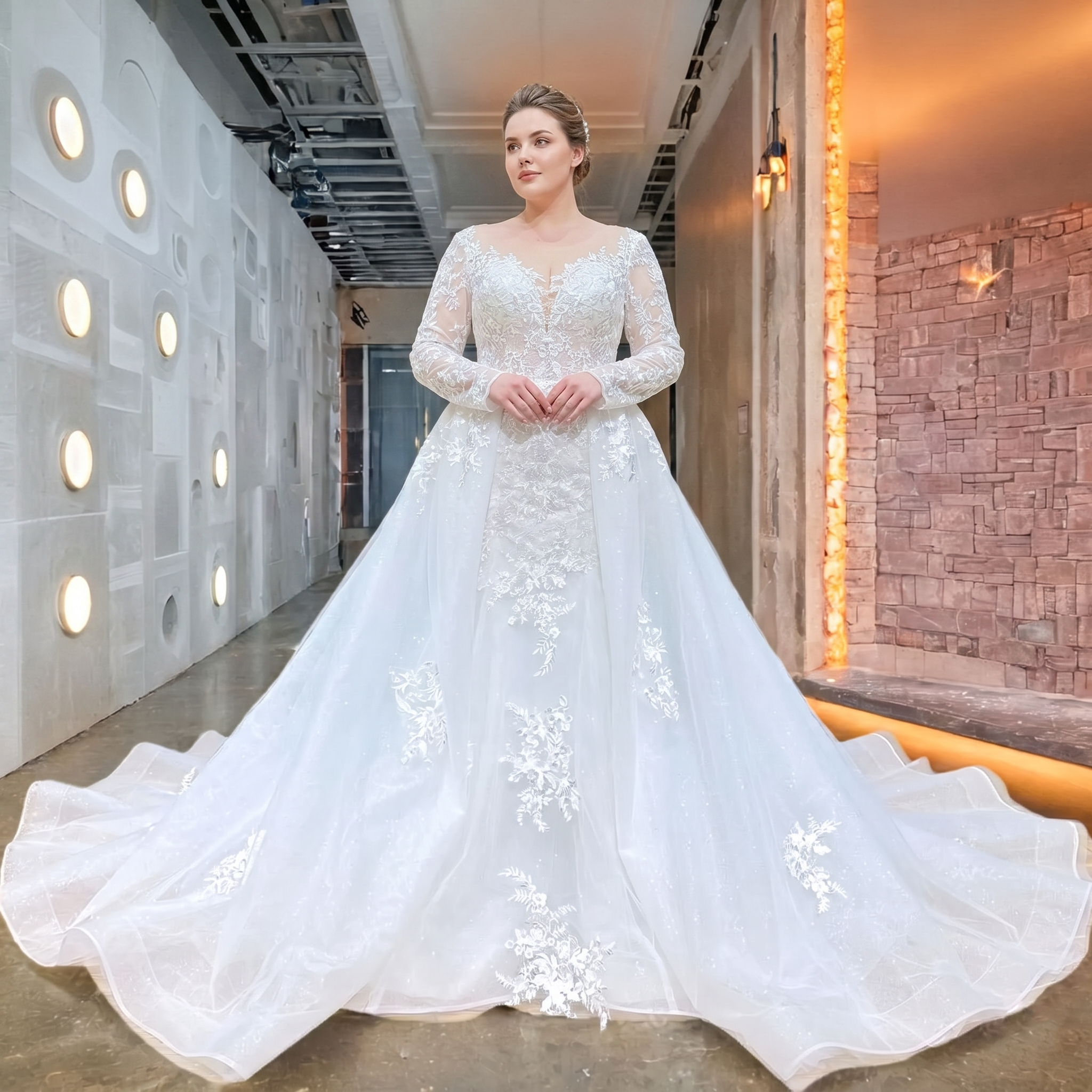 Full-length front view of a plus-size bride wearing an elegant long sleeve mermaid wedding dress, highlighted by detailed lace appliques and a majestic detachable train.