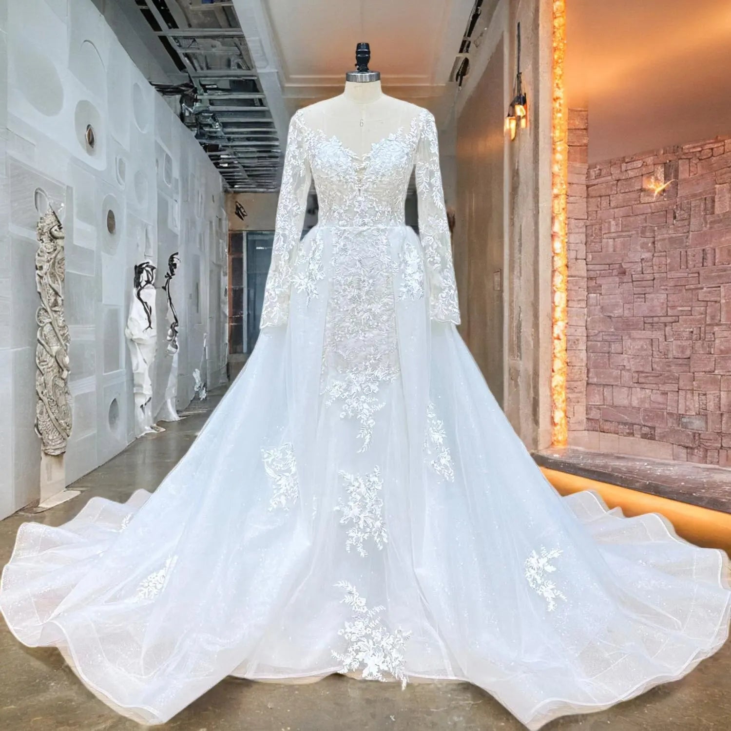 Mannequin display of an elegant long sleeve mermaid wedding dress showcasing its sheer illusion neckline, intricate lace bodice, and shimmering detachable train.
