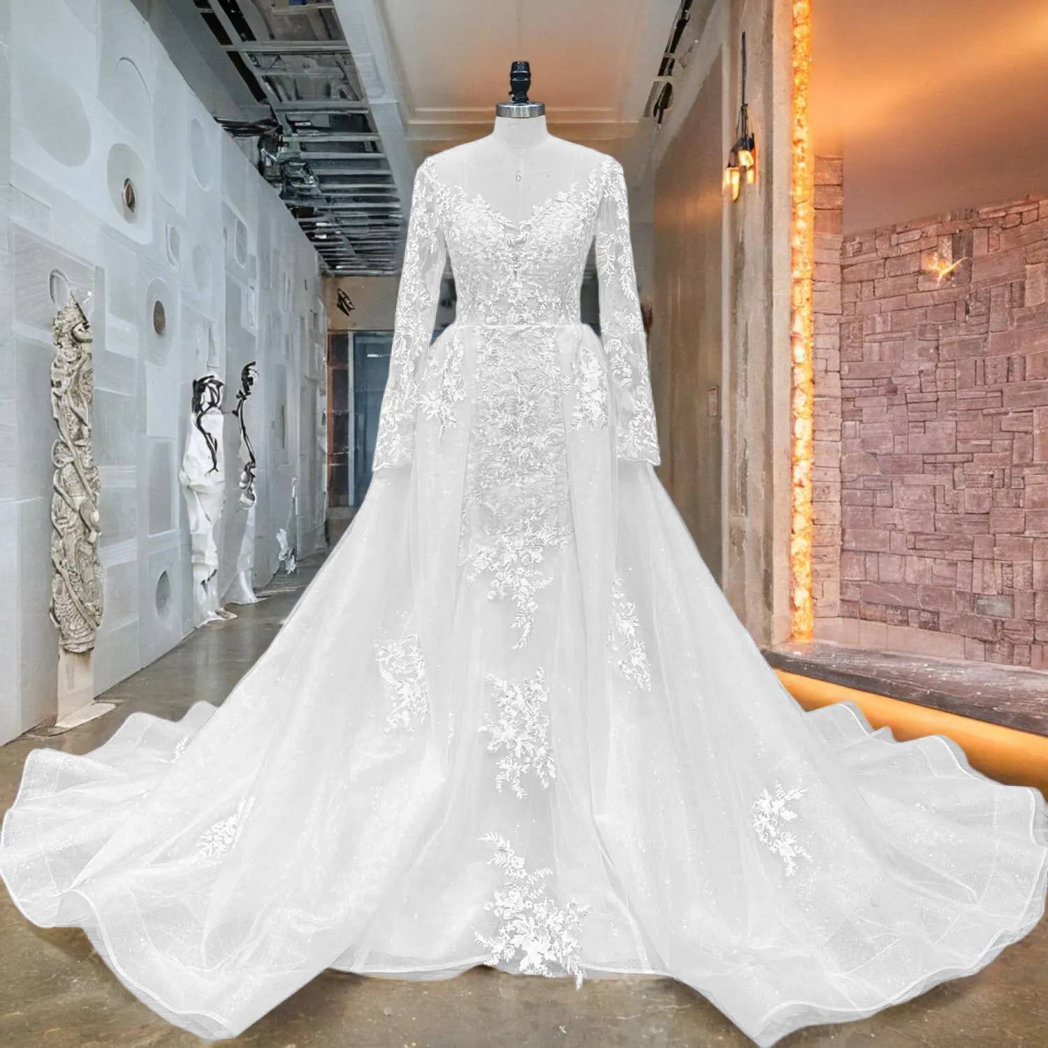 Front view of an elegant long sleeve mermaid wedding dress on a mannequin in a studio, featuring a deep V illusion neckline, heavy lace appliques, and a grand detachable train.