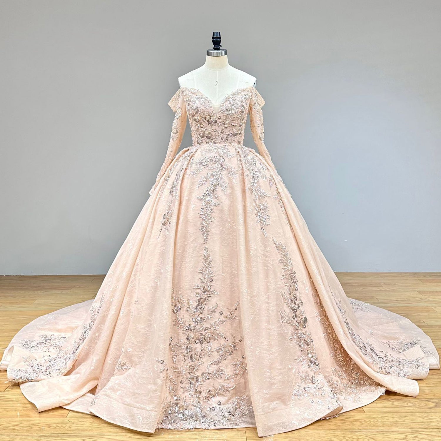 Classic studio shot of a long sleeve wedding dress with a sweetheart neckline, perfectly capturing the regal silhouette and luxurious beaded lace textures.