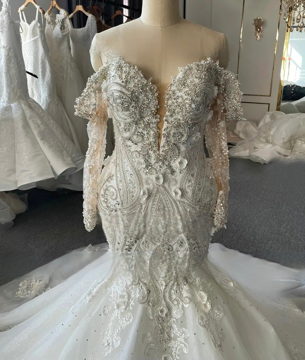 Close-up shot of the off-the-shoulder lace sleeves and sweetheart neckline of the mermaid wedding dress, focusing on the luxury hand-beaded textures.