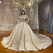 Full front view of a model wearing an elegant luxury ball gown bridal dress featuring a heavily beaded bodice, high-neck illusion collar, long sleeves, and a massive shimmering cathedral train.