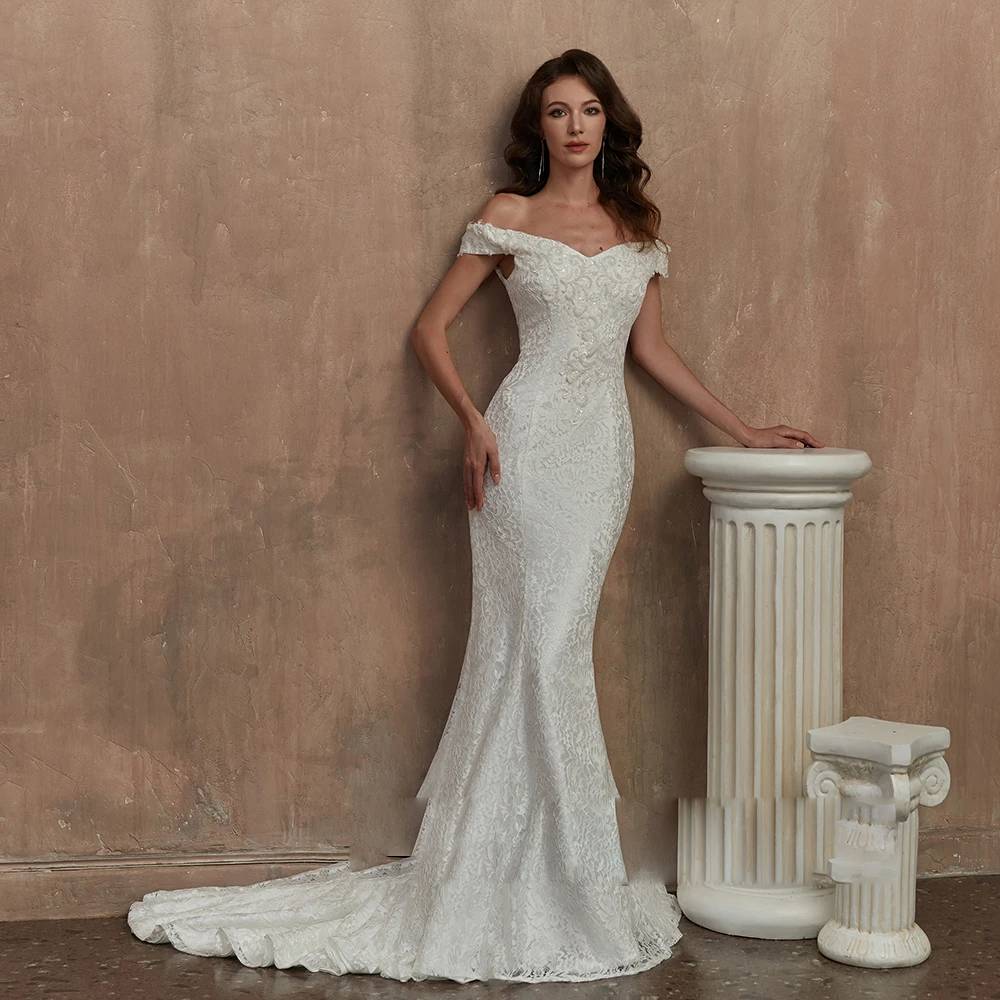 Model posing in a slim-fit mermaid wedding dress with all-over floral lace, showcasing the full floor-length train.