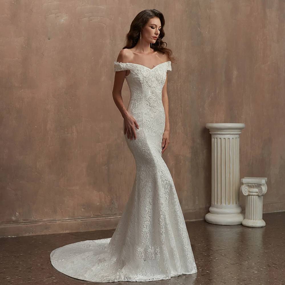 Side profile of an elegant off-the-shoulder lace bridal gown, showcasing the fitted hourglass silhouette and trumpet flare