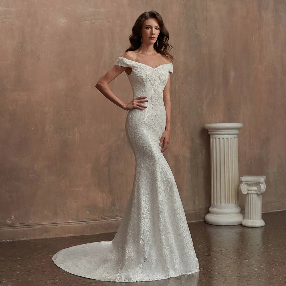 Three-quarter front view of a romantic mermaid-style lace wedding dress with structured off-the-shoulder sleeves.