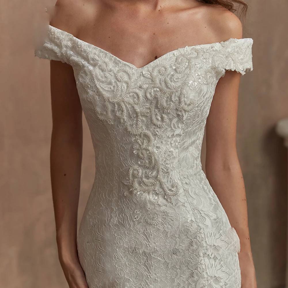 Close-up detail of a bridal gown bodice featuring intricate floral lace embroidery, subtle beadwork, and a sweetheart neckline.