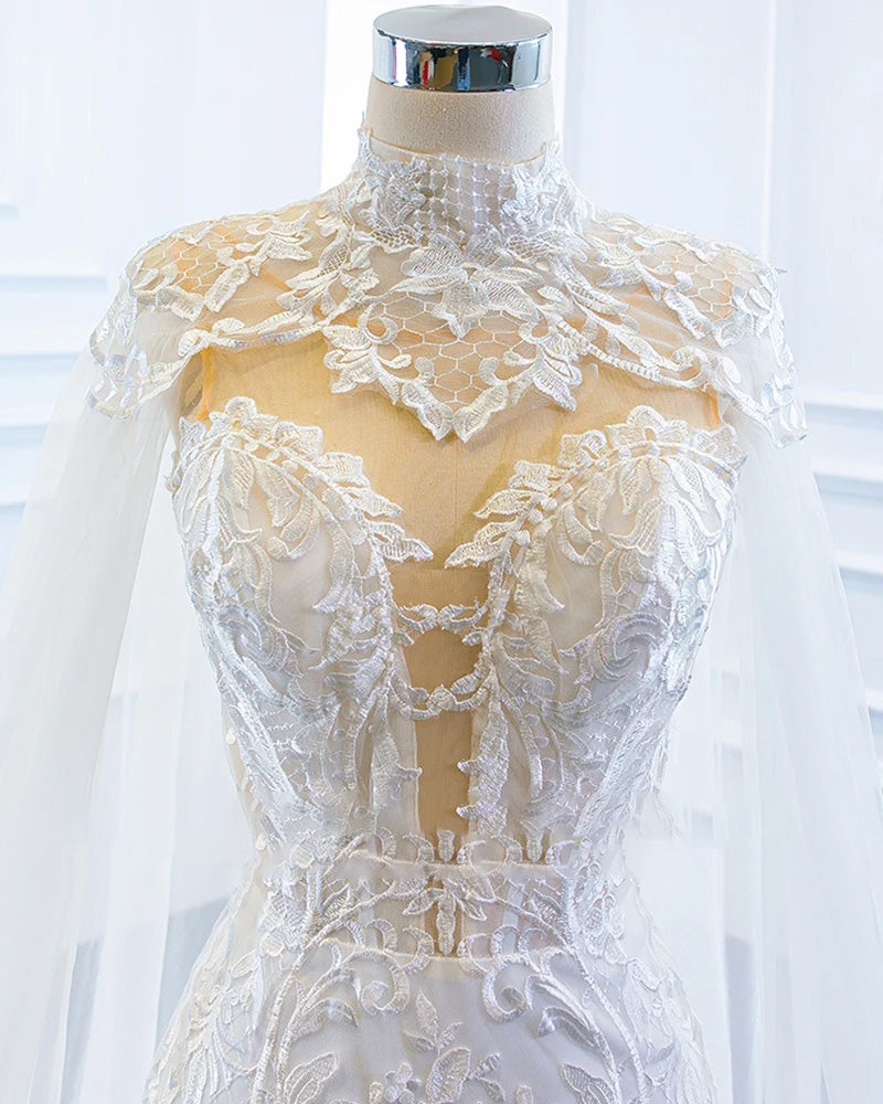 A mannequin displaying an elegant off-the-shoulder mermaid wedding dress paired with a matching shawl, showcasing a sophisticated bridal silhouette.