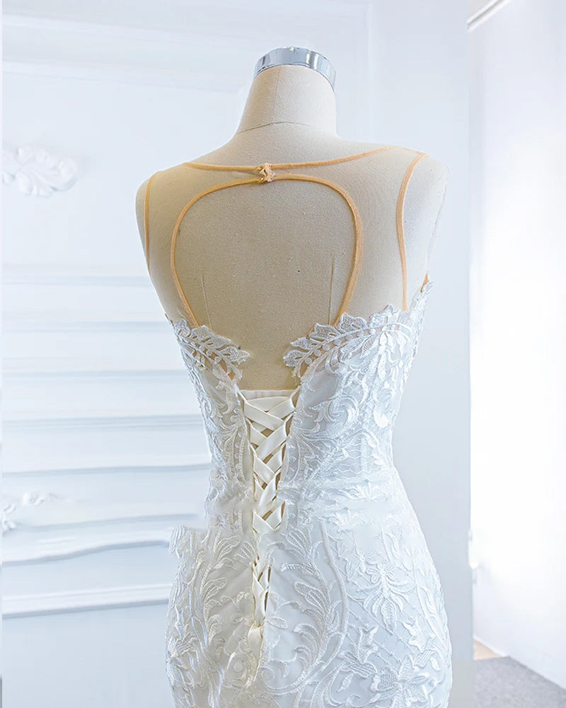 Close-up detail of the off-shoulder bodice and matching shawl on a luxury mermaid wedding gown, highlighting intricate lace craftsmanship.